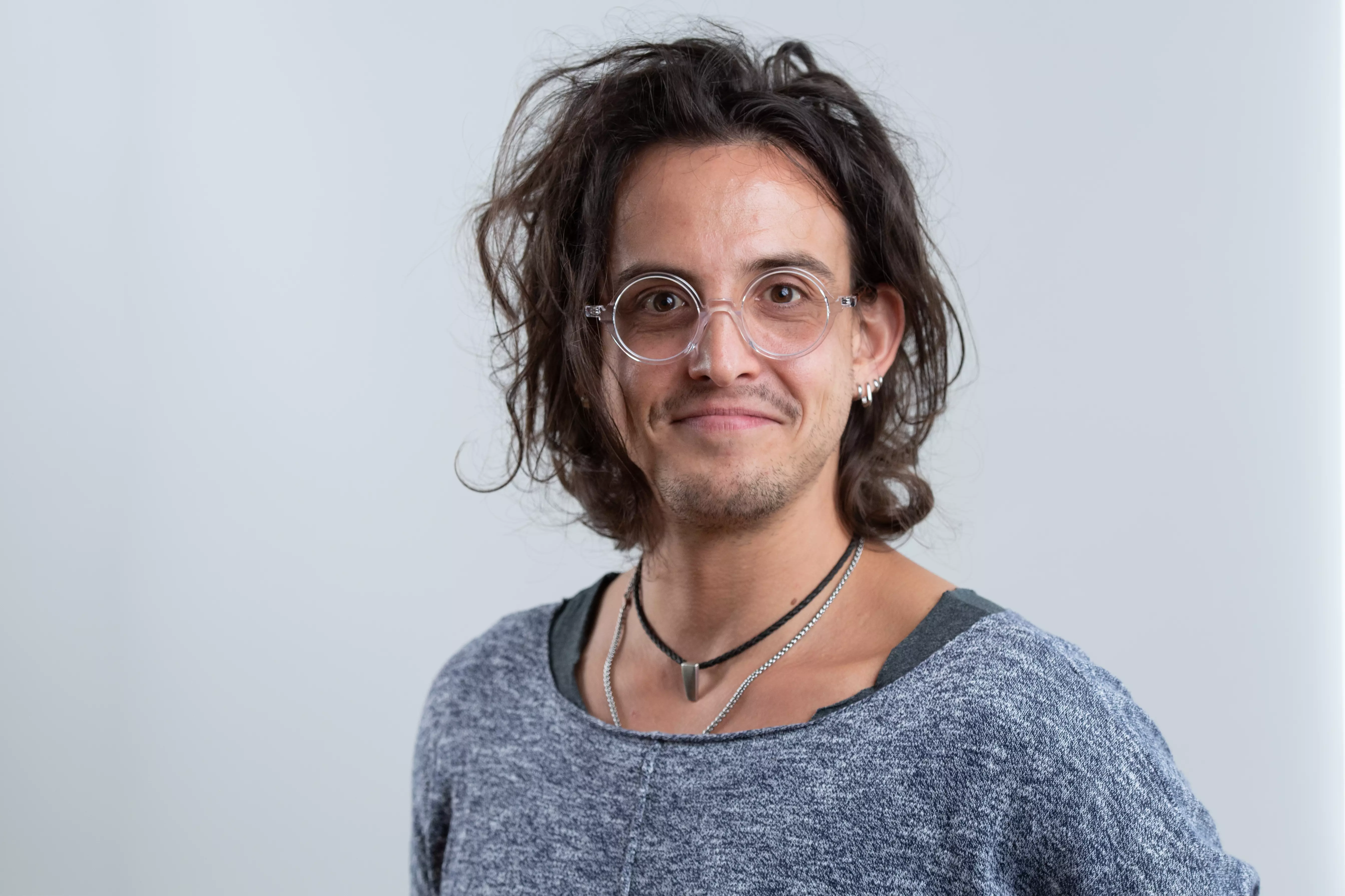 headshot of a man with glasses and a grey jumper 