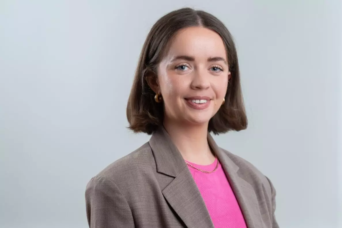 Headshot of a woman in a blazer and pink top